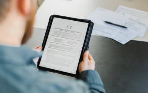 man writing his cv, considering whether it is illegal to lie on your cv or not