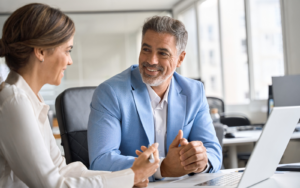 Two business people smiling discussing how to hire an IT manager