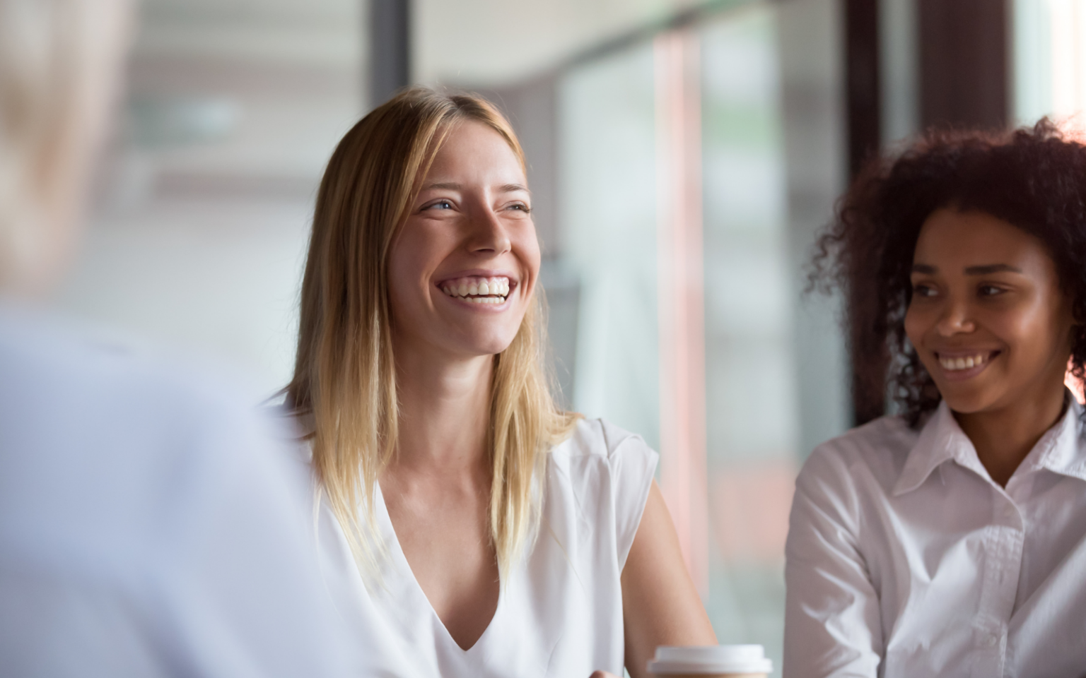 Two women in AI leadership sitting at a table looking happy